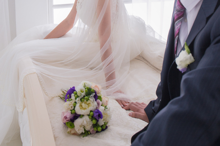bride and groom sit together on the bedの写真素材