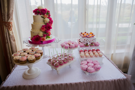 wedding cake near the candy bar on the tableの写真素材