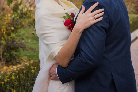 bride and groom stand together on the street in autumnの写真素材