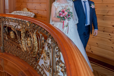 bride and groom walk down the hall with beautiful railingsの写真素材