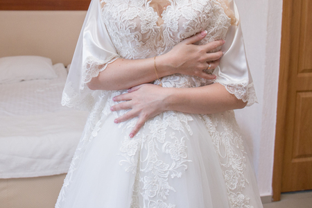 bride in dressing gown holding wedding dressの写真素材