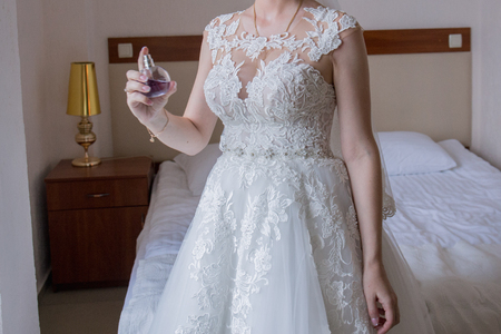 the bride in a wedding dress sprays perfumeの写真素材