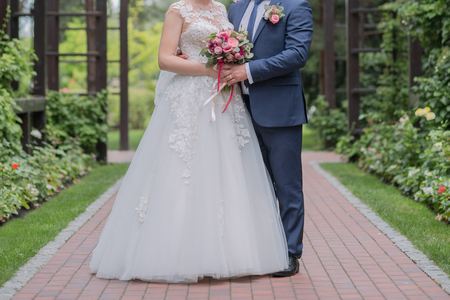 bride and groom and wedding bouquet in the parkの写真素材