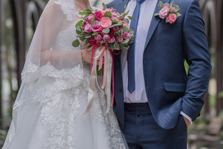 bride and groom and wedding bouquet in the parkの写真素材