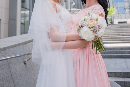 bride with bridesmaid in pink dress huggingの写真素材