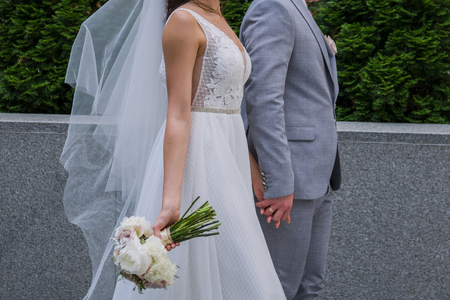 The bride and groom are standing together near the office building.の写真素材