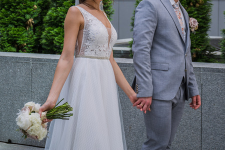 The bride and groom are standing together near the office building.の写真素材