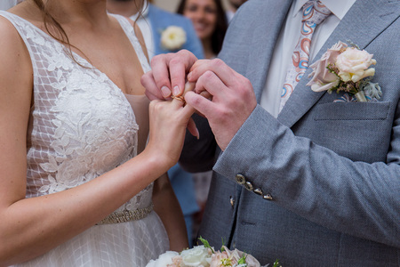 The bride and groom stand together in an embrace in the park