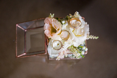 glass box with gold rings and flowers