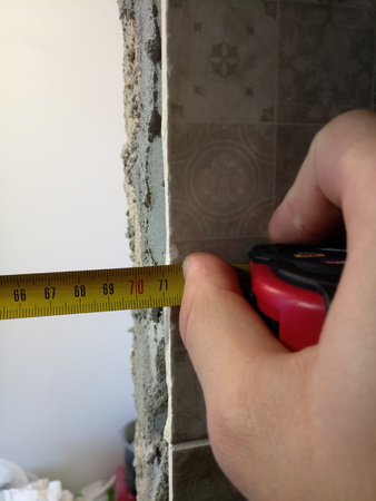 measuring walls with a tape measure for repairの写真素材