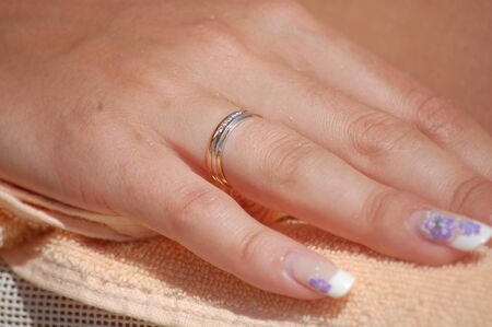 wedding ring on womans hand with manicureの写真素材