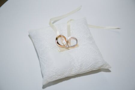 gold wedding rings on pillow for ringsの写真素材