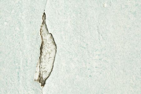 cracked white wall with fallen white paint crackの写真素材