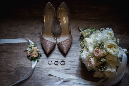 wedding rings near the shoes the brideの写真素材