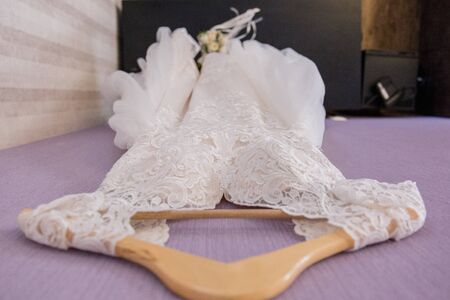 wedding dress hanging on hanger in the roomの写真素材