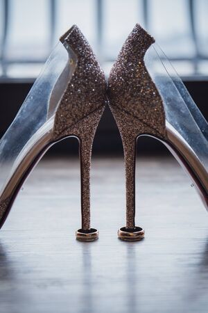 shoes of the bride with wedding rings on floorの写真素材