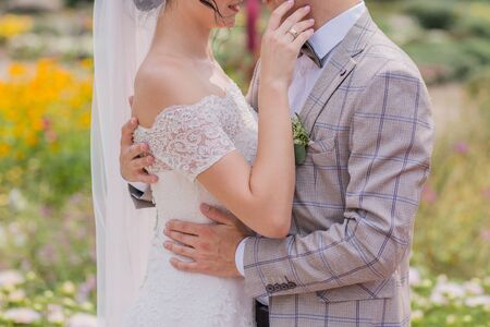 bride and groom in park with flowersの写真素材