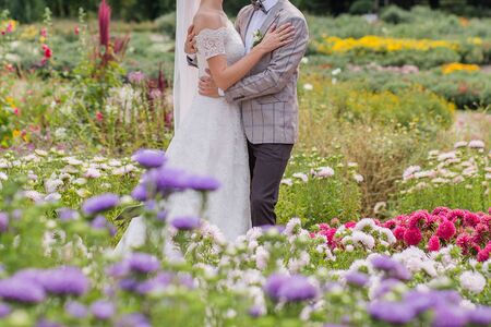 bride and groom in park with flowersの写真素材