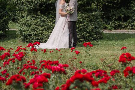 bride and groom in park with flowersの写真素材