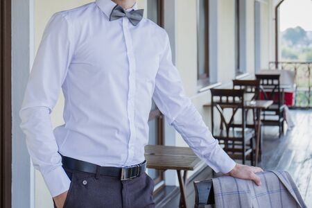 man puts on suit on the verandaの写真素材