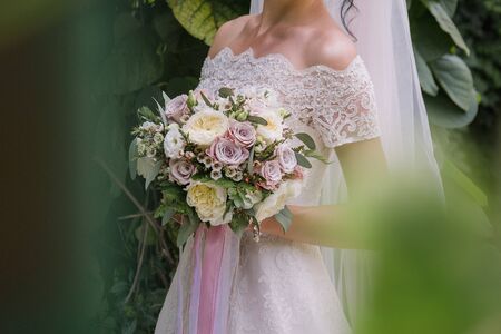 bride with bouquet of flowers in the parkの写真素材