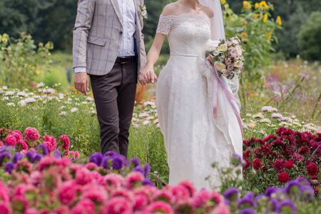 bride and groom in park with flowersの写真素材