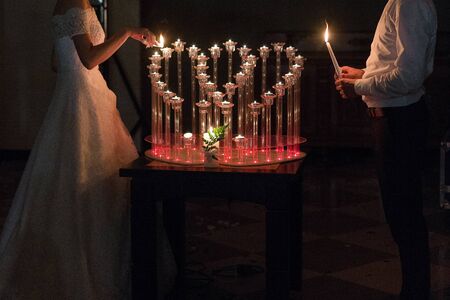 bride and groom light candles at weddingの写真素材