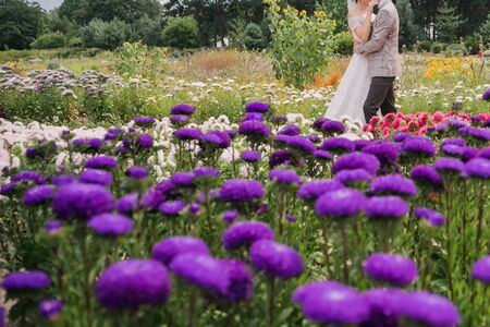 bride and groom in park with flowersの写真素材