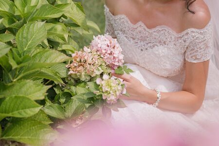 bride with bouquet of flowers in the parkの写真素材