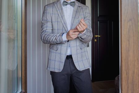 man puts on suit on the verandaの写真素材