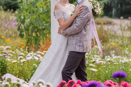 bride and groom in park with flowersの写真素材
