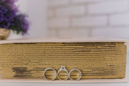 wedding rings near a book on the tableの写真素材