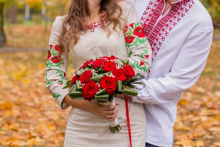 a man with woman in folk clothes in autumnの写真素材