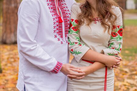 a man with woman in folk clothes in autumnの写真素材