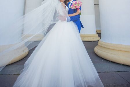 bride and groom near building with columnsの写真素材