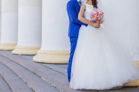 bride and groom near building with columnsの写真素材