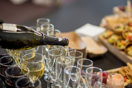 a waiter pour champagne into glassesの写真素材