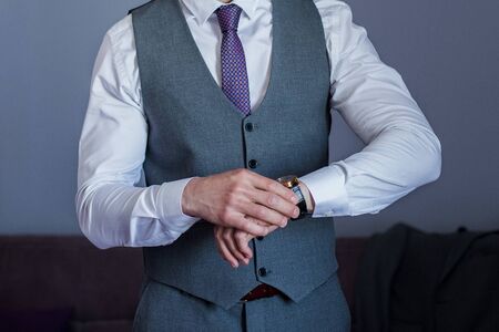 man puts on suit in the roomの写真素材