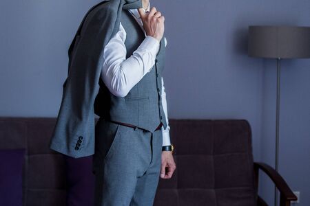 man puts on suit in the roomの写真素材