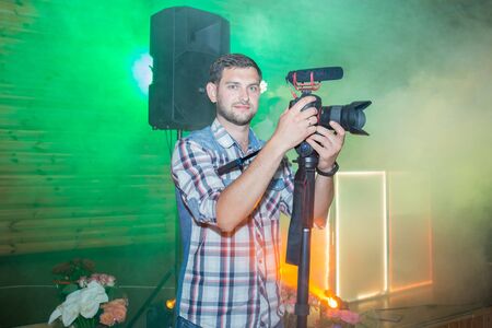 man in a shirt with a monopod and a camera