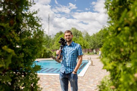 man in a shirt with a monopod and a cameraの写真素材