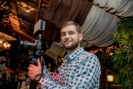 a man with beard holding a camera and a monopodの写真素材