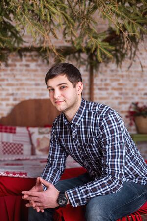 a man in plaid shirt in an armchairの写真素材