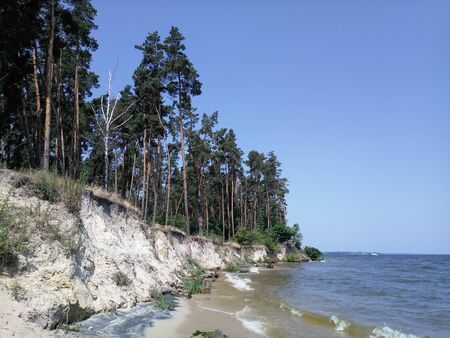 a river bank with cliff and treesの写真素材