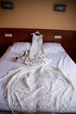 wedding dress lies on bedの写真素材