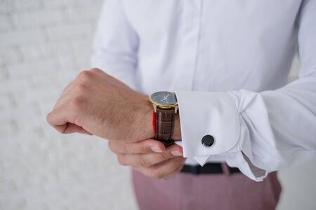 man puts watch on his handの写真素材