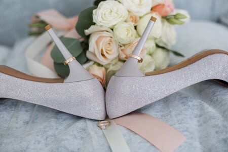 shoes of the bride with rings and bouquetの写真素材