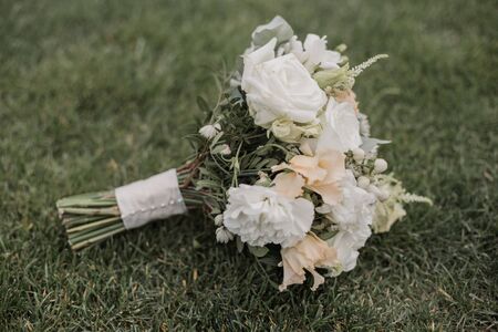 bridal bouquet of flowers lies in grassの写真素材