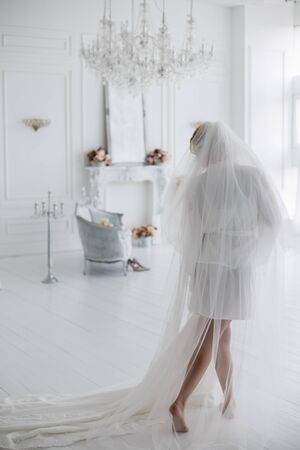 a bride in peignoir with wedding dressの写真素材
