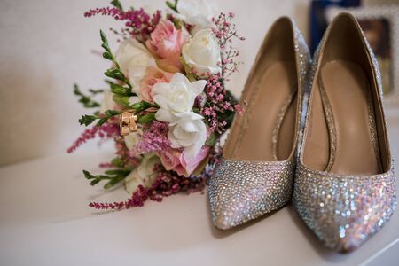 a wedding gold rings with bride shoes and decorの写真素材